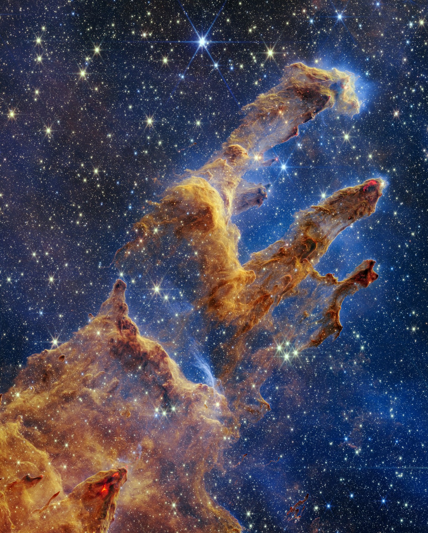 Take some time to enjoy the universe.

6,500 light-years away from Earth, the dusty Pillars of Creation reach out into the cosmos like a giant hand. Young stars are forming within this region of the Eagle Nebula, some "only" a few hundred thousand years old.

Our orbiting @NASAWebb telescope captured this view of the Pillars in 2022. Previous images from other telescopes, taken with visible light, were much more opaque—but Webb's near-infrared vision allows it to partially see through these pillars of gas and dust, revealing the stars within. Scientists are using these findings to understand how stars are born and develop into solar systems like our own.

Image description: Layers of semi-opaque, rusty-red gas and dust reach out from the bottom left of the image, forming finger-like pillars that extend into the top right. Peeking through the layers of gas and dust is the background, set in shades of blue and littered with tiny yellow and blue stars. Many of the tips of the pillars appear tinged with what looks like lava. There are also tiny red dots at the edges of the pillars, which are newly-born stars.

Credit: NASA, ESA, CSA, STScI

#NASA #Webb #Universe #Mindfulness