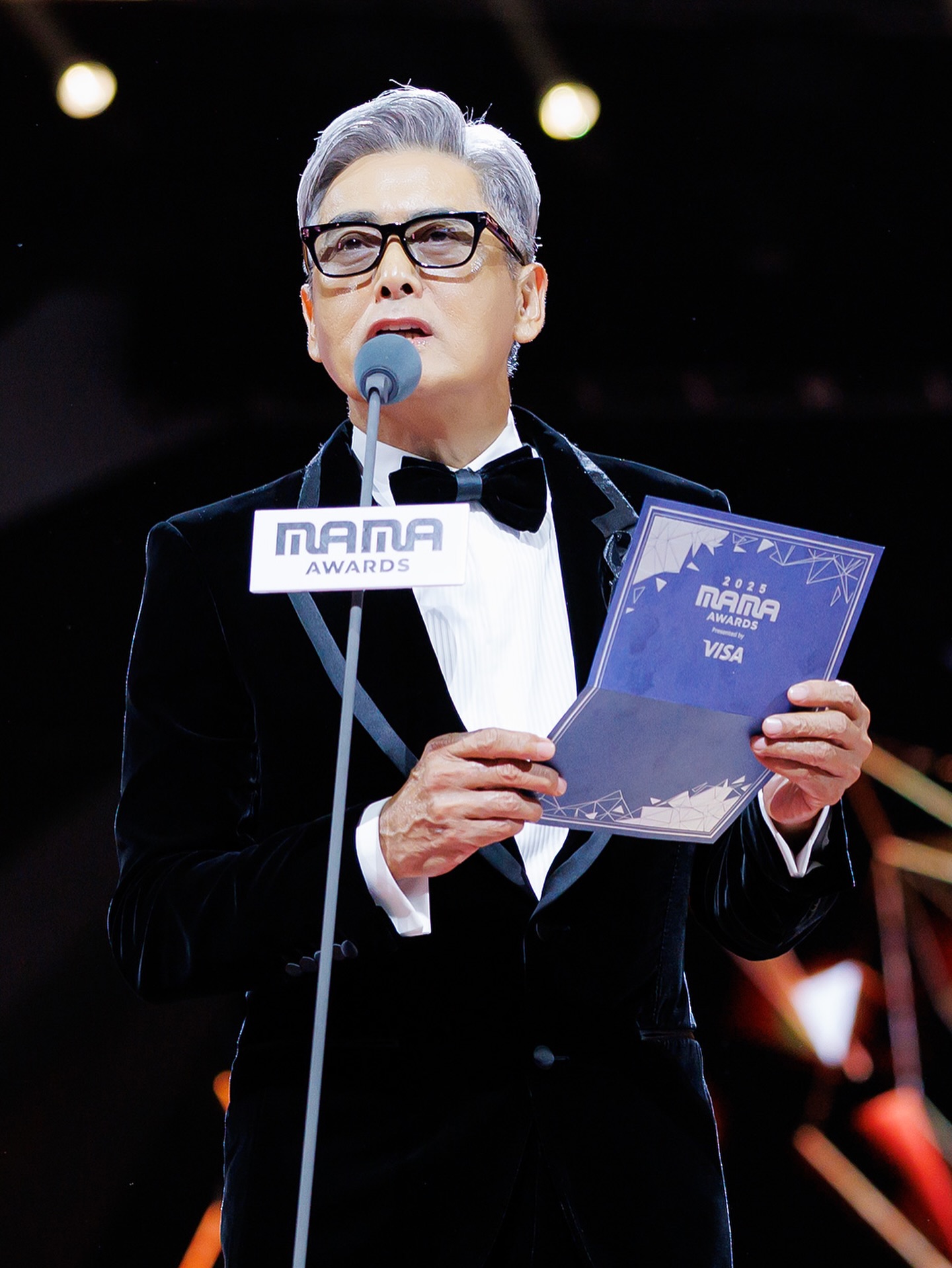 大埔宏福苑火災慘劇，為香港帶來沉重打擊，MAMA 2025 大會臨時應變以「Support Hong Kong」為主題貫徹悼念，所有頒獎嘉賓統一佩戴黑絲帶調整節目安排獲讚，周潤發壓軸登場籲全場起立為大埔火災默哀，向災民送上最真摯的慰問！今屆 MAMA 遇上大埔突發火災，主辦方迅速而果斷的節目調整，不但取消紅毯、大幅縮減燈光與特效、整體音量壓低，更改主題以「Support Hong Kong」悼念遇難者，所有頒獎嘉賓統一佩戴黑絲帶，各韓星單位表演造型都馬上改為黑、白低調服飾。MAMA翌日發哥身穿筆挺的素黑西裝，負責頒發全晚最高榮譽——「年度藝人」大獎。在揭曉得獎者前，發哥神情肅穆，以沉穩溫柔的語調請求全場起立，帶領來自世界各地的藝人與粉絲，一同為大埔火災的遇難者與傷者默哀致意。這一分鐘的靜默，展現了對生命的最高尊重，也讓 MAMA 2025 留下了最溫暖且具人性光輝的一頁。不少韓國娛樂公司如 @hybe.labels 、 @smtown 等及旗下藝人分別捐款，為災民渡過難關，令人感動。

📸 @mnet_mama 
Follow us @ellemenhk 

#ELLEMEN #ELLEMENHK #ELLEMENCELEB #MAMA2025 #gdragon #周潤發 #ive #cortis #enhypen #idle #æspa #superjunior #ellemenmolly